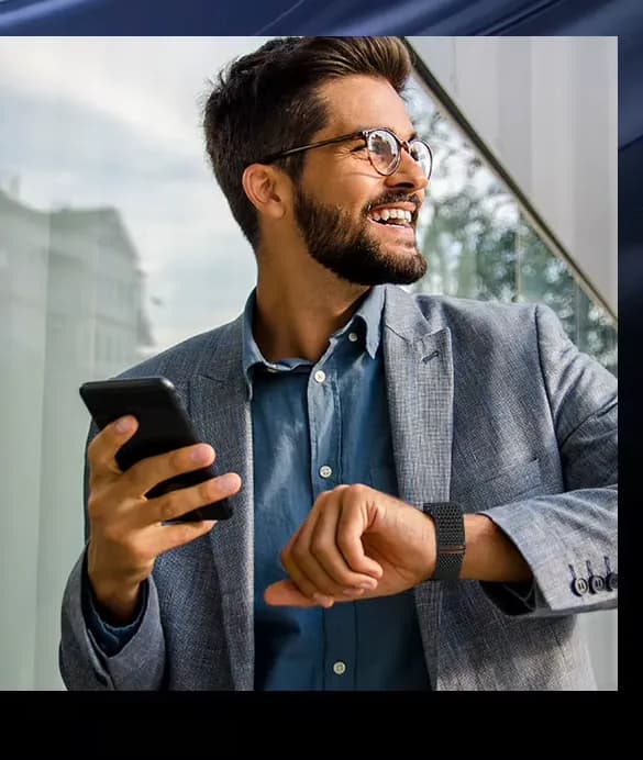 A man in a blazer glances at his wrist while holding a phone